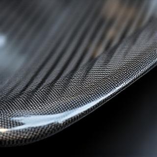 Close-up of a carbon fiber aerodynamic car part being detailed.